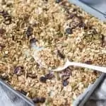 baking tray of nut free granola with white spoon resting on tray
