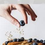 Hand putting blueberry on top of banana cake with text The Non Diet Approach