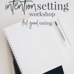 Note pads and pens on a desk with a keyboard in the background. Text overlay reads: intention setting workshop. feel good eating