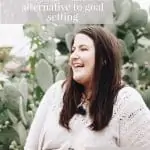 Image of a white woman with brown hair in a larger body standing in front of a big cactus. She is wearing a cream coloured top. There is a text overlay that reads: Living in alignment with your values: an alternative to goal setting. feel good eating