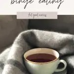 A mint green china tea cup with tea sits nestled in a blanket. This is a soothing option after binge eating. There is text overlay that reads: what to do after binge eating